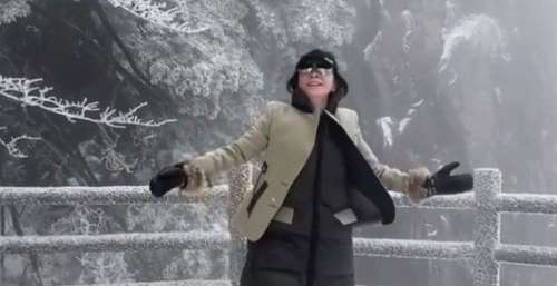 刘嘉玲在黄山雪地里跳舞，捧着雪抛向空中，开心得像个孩子
