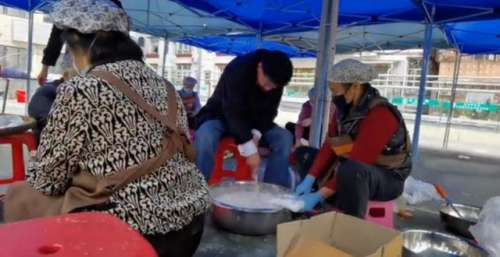 64岁万梓良简陋大棚里做小吃，被一群阿姨环绕，拿木棍搅拌太卖力